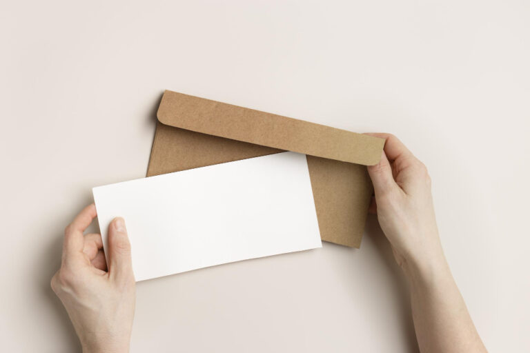 Mãos segurando envelope para correio personalizado, pronto para envio empresarial